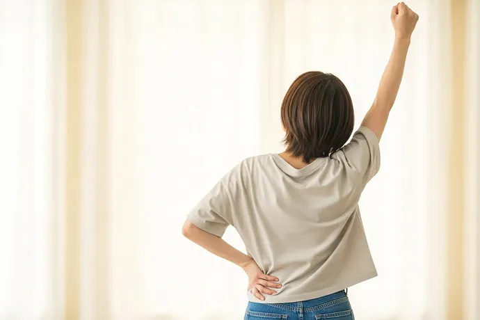 右手を高く上げている女性の様子